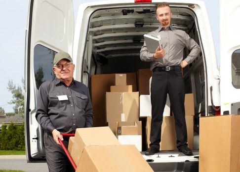 Flat removal team carrying boxes in a UK apartment building