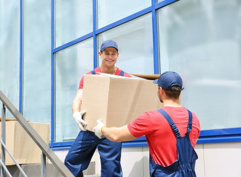 Removal team calculating load-based pricing with packed household items