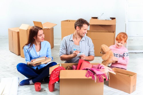 House removalists loading packed boxes into a moving van in the UK