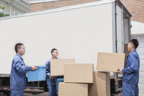 Worker wearing PPE while moving boxes and furniture