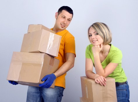 Professional movers transporting furniture through a corridor